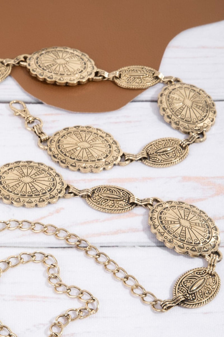 The Concho Disc Chain Belt in Antique Gold - Flat Lay on Marble Surface Showing Full Belt Length — Concho Discs, Curb Chain Links & Oval Charm Pendant