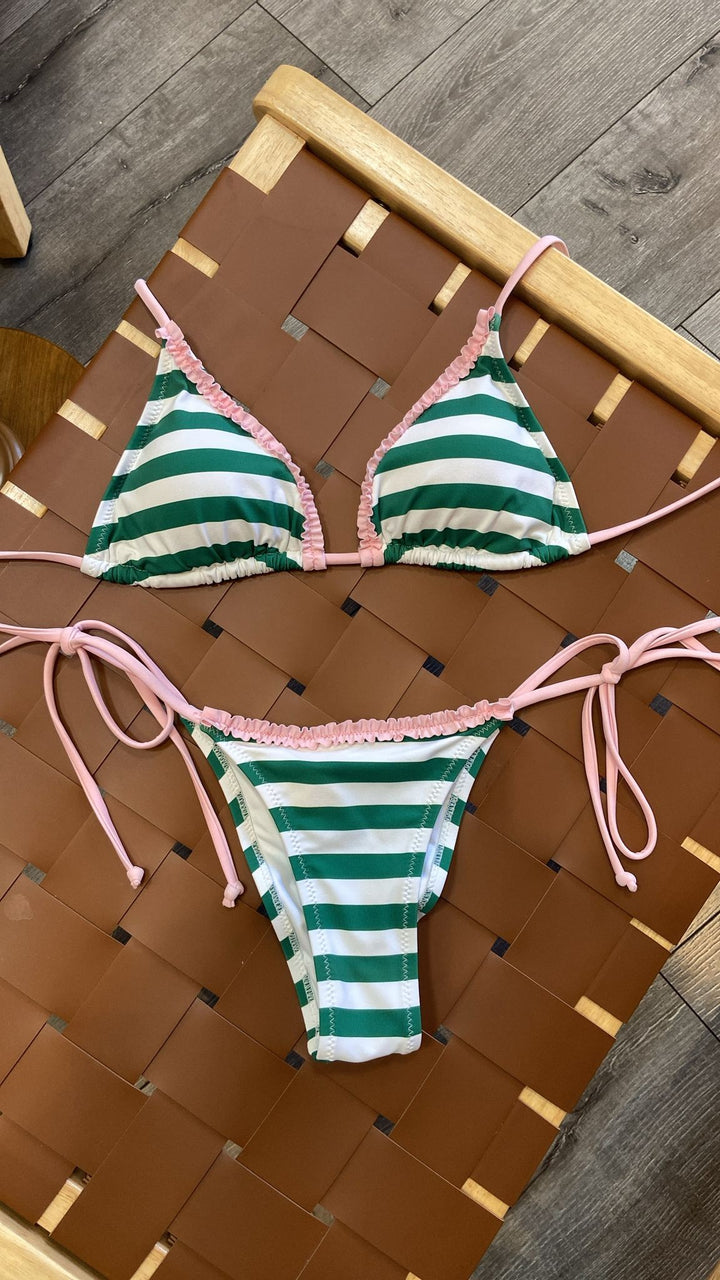 The Sunny Days Bikini Set - Flat Lay on Rattan Surface Showing Full Set Detail — Green Stripe, Pink Ruffle Trim & Pink String Ties