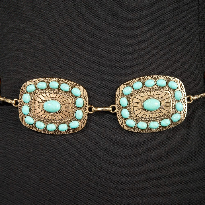 The Mesa Turquoise Rectangle Concho Chain Belt in Gold - Close-Up Detail on Dark Background Showing Two Rectangle Concho Plaques with Turquoise Cabochon Center Stone & Halo Stud Cluster