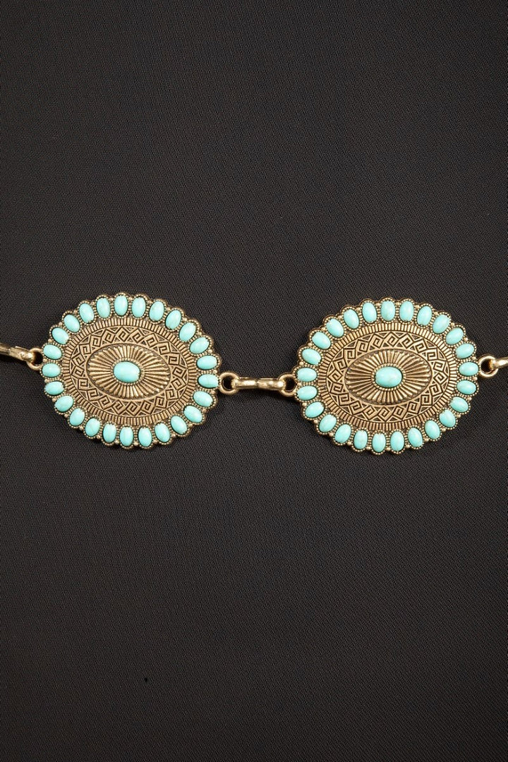 The Turquoise Concho Chain Belt - Close-Up Detail on Dark Background Showing Sunburst Engraving, Turquoise Stud Border & Center Stone on Two Concho Discs