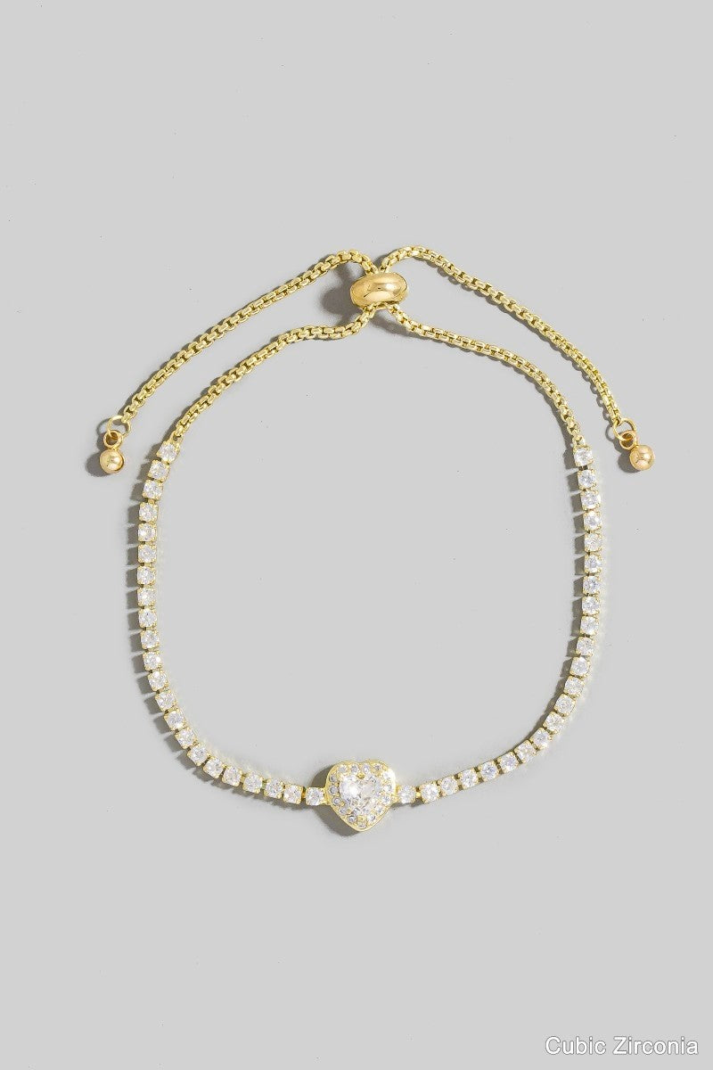 Gold bracelet with heart-shaped clasp on a gray background