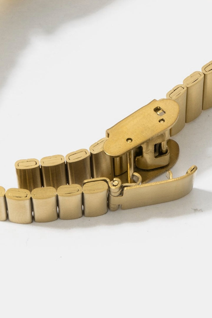 The Cushion Rectangle Bangle Watch in Gold - Close-Up Detail Shot of Fold-Over Clasp with Push-Button Release Showing Ribbed Band Link Construction & Gold Tone Finish