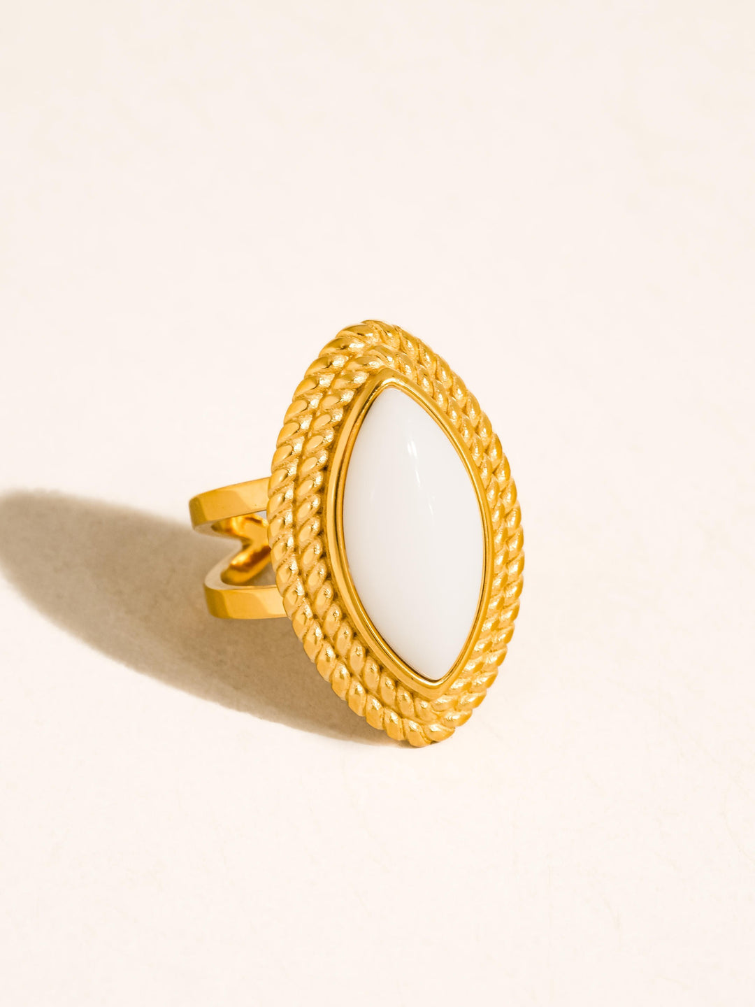 The Vintage Marquise Stone Statement Ring in 18K Gold - Product Shot on Cream Background Showing Three-Quarter View of Oversized White Marquise Stone in Double-Row Rope Bezel with Split Double Band