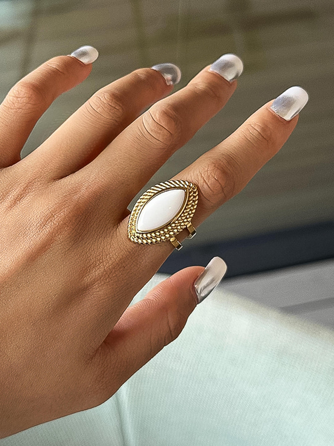 The Vintage Marquise Stone Statement Ring in 18K Gold - On-Model Lifestyle Shot Showing Ring Worn on Middle Finger Against White Linen Background Displaying Full Marquise Stone Face & Rope Bezel Frame