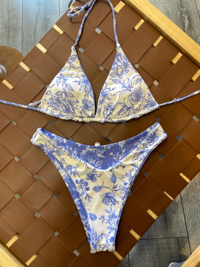 The Jane Reversible Bikini Set - Flat Lay on Rattan Surface Showing Side 2 White Floral Triangle Top & Full Coverage Bottoms