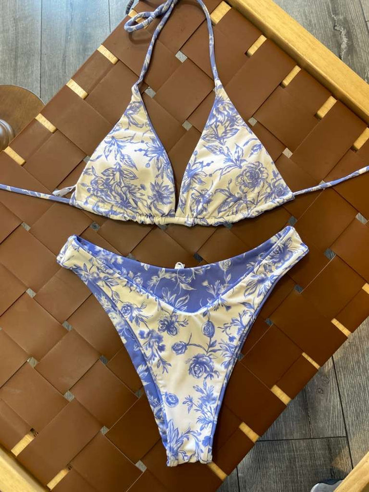 The Jane Reversible Bikini Set - Flat Lay on Rattan Surface Showing Side 2 White Floral Triangle Top & Full Coverage Bottoms