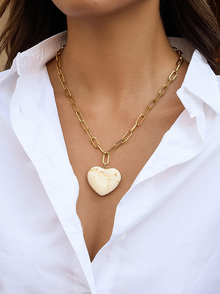 The Resin Heart Paperclip Chain Necklace in 18K Gold Cream Marble - On-Model Shot Showing Oversized Cream Marble Resin Heart Pendant on Chunky Gold Paperclip Chain Against Open White Linen Button-Down