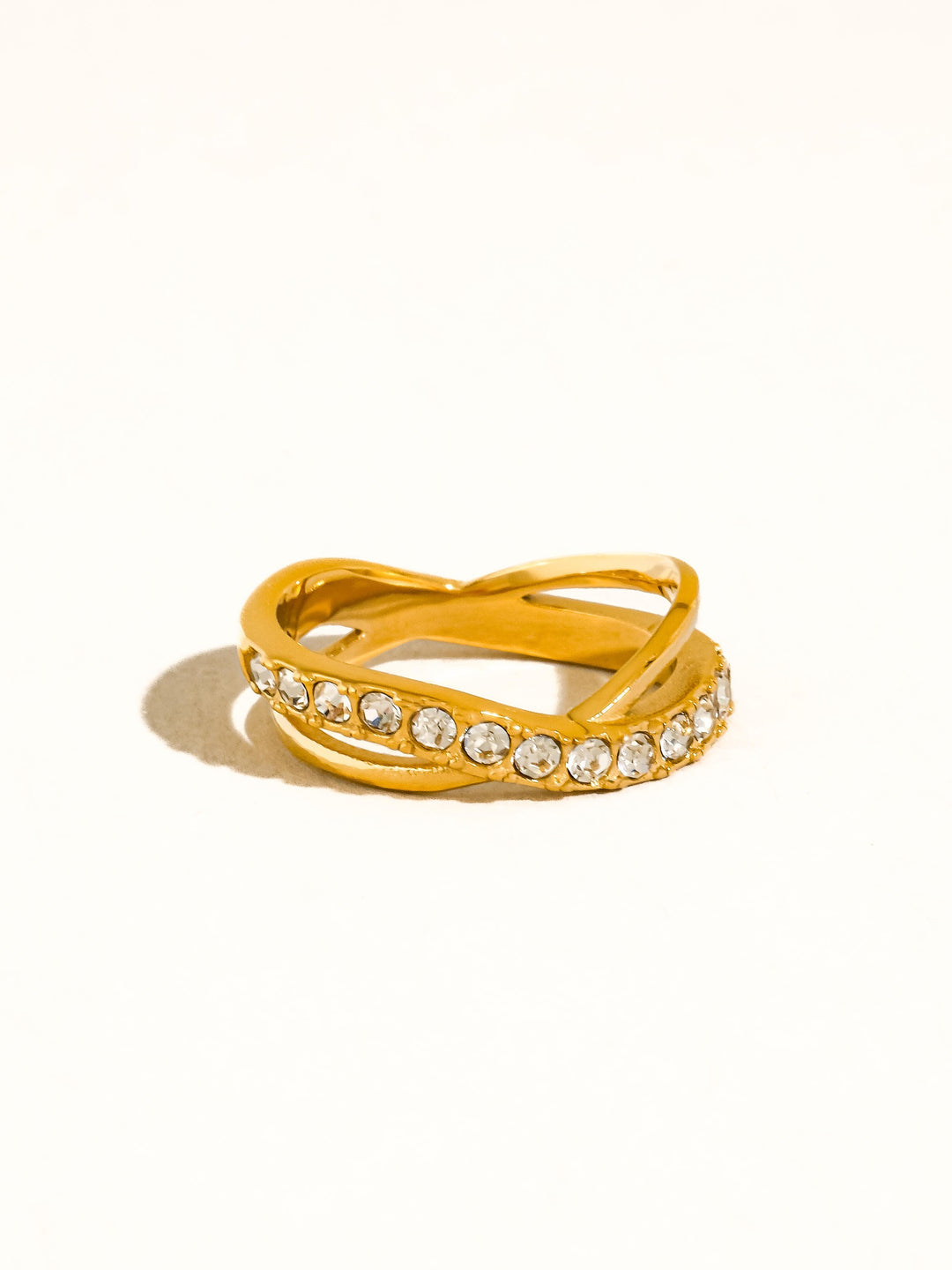 The CZ Pavé Crossover Ring in 18K Gold - Three-Quarter Product Shot on Cream Background Showing Crossover X Profile, Full Pavé CZ Band Detail & 18K Gold Finish
