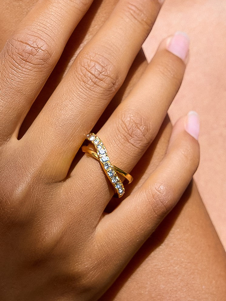 The CZ Pavé Crossover Ring in 18K Gold - On-Model Close-Up on Hand Showing Crossover X Ring Worn on Ring Finger with Pavé CZ Band Catching Light Against Warm Skin Tone