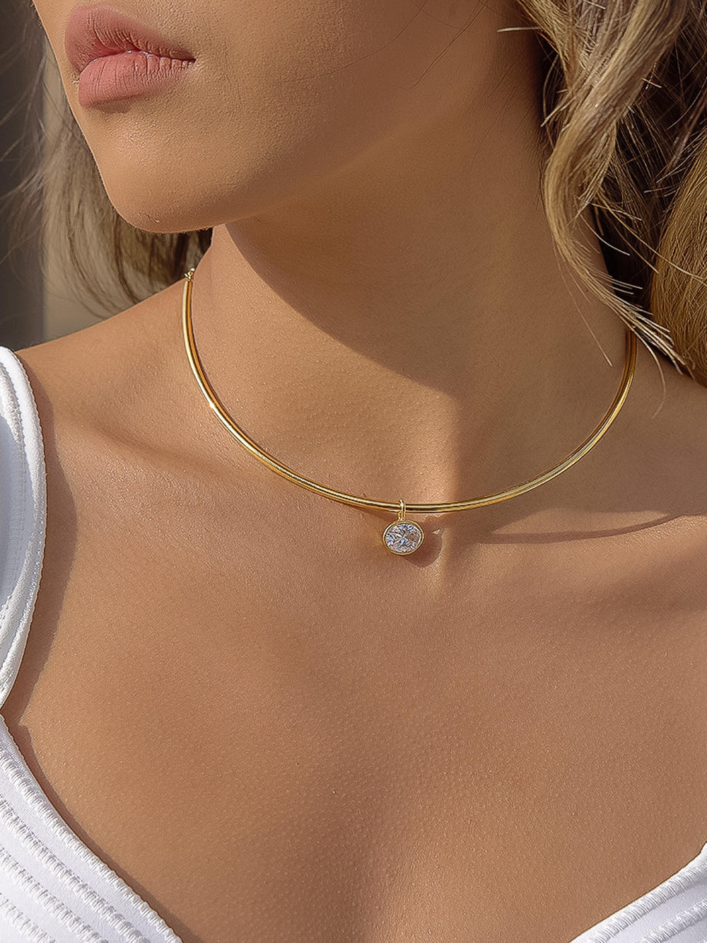 The Classic CZ Bezel Wire Choker in 18K Gold - On-Model Shot Showing Sleek Double-Wire Gold Choker with Oval CZ Bezel Drop Resting at Base of Neck Against Warm Skin & White Tank Top