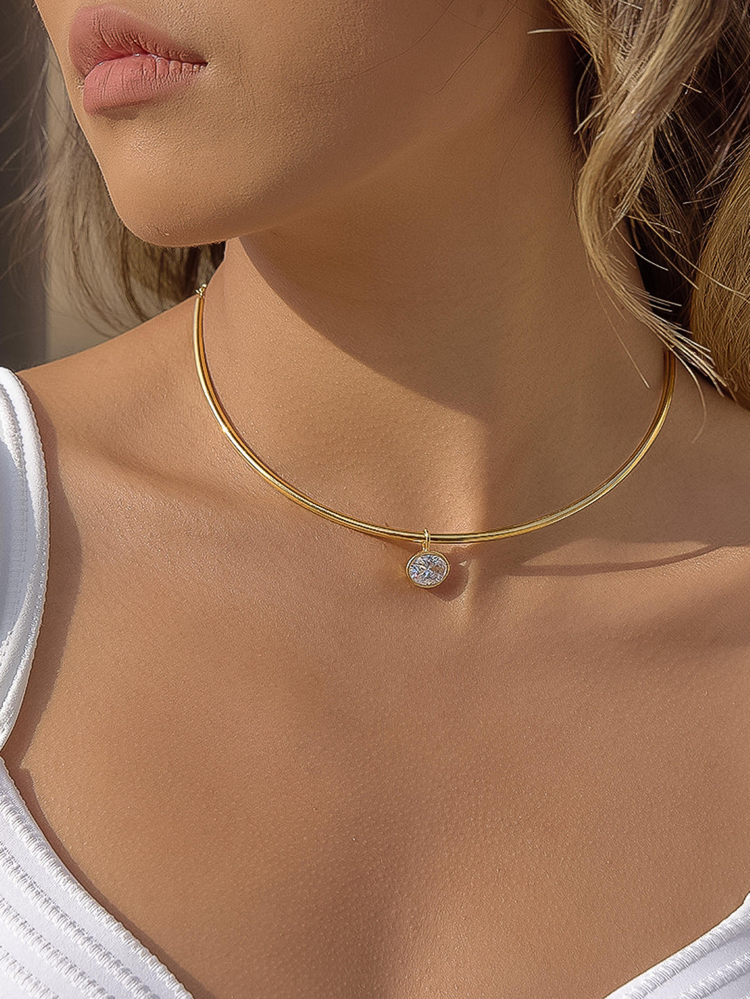 The Classic CZ Bezel Wire Choker in 18K Gold - On-Model Shot Showing Sleek Double-Wire Gold Choker with Oval CZ Bezel Drop Resting at Base of Neck Against Warm Skin & White Tank Top