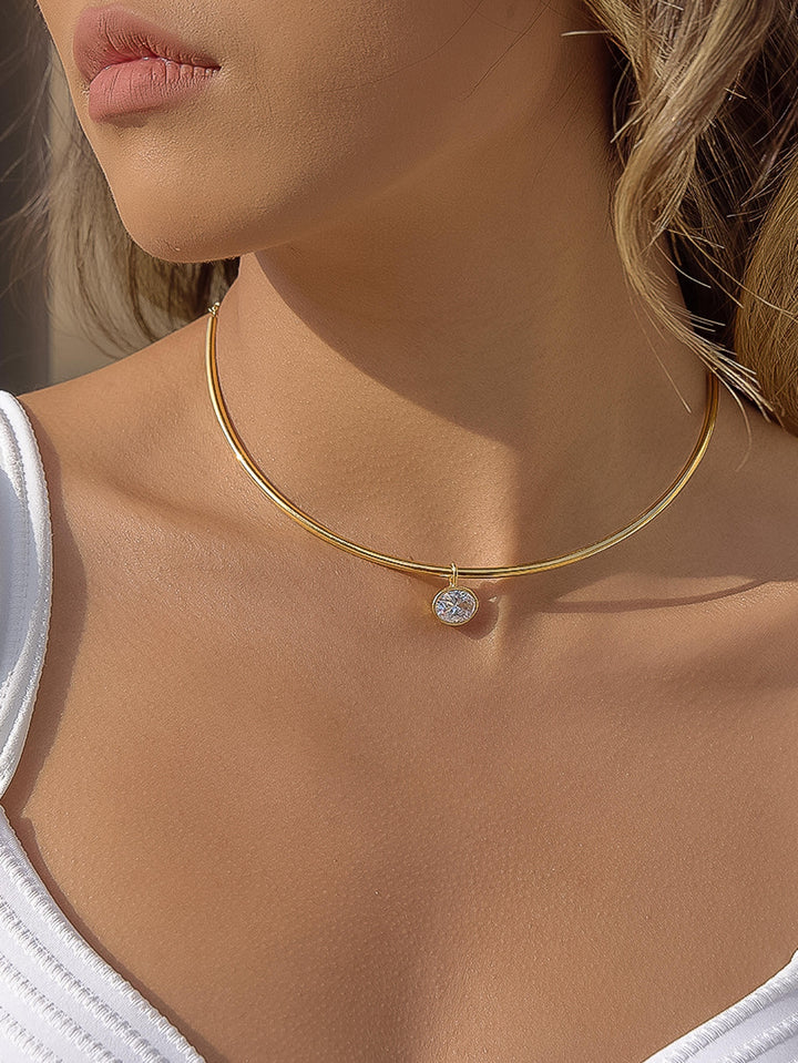 The Classic CZ Bezel Wire Choker in 18K Gold - On-Model Shot Showing Sleek Double-Wire Gold Choker with Oval CZ Bezel Drop Resting at Base of Neck Against Warm Skin & White Tank Top