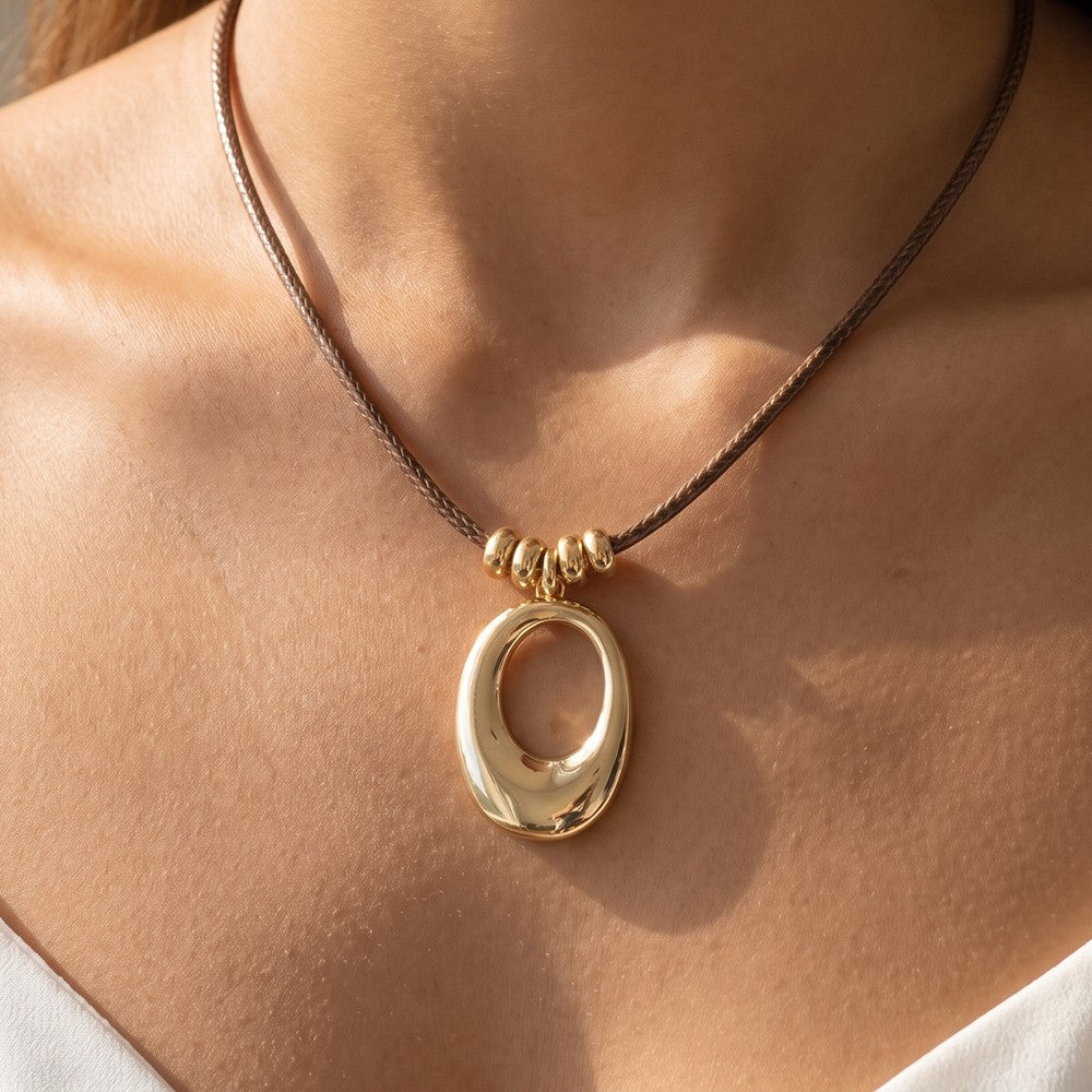 Sculptural Open Oval Pendant Woven Cord Necklace Gold