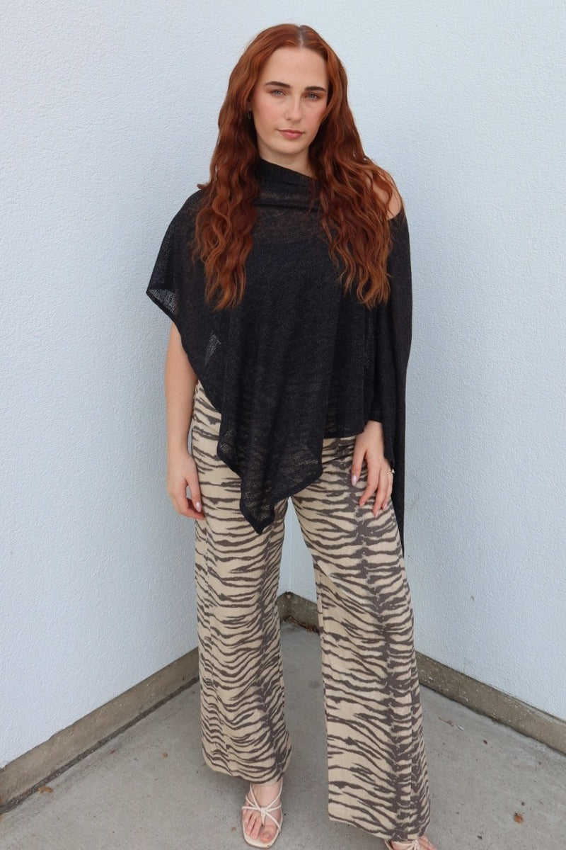Front view of the black Portofino sheer knit poncho top, showing the pointed asymmetric hem