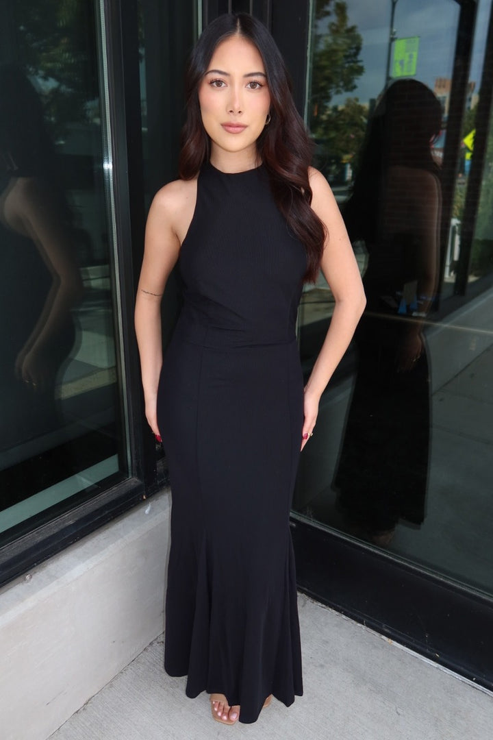 Model wearing the black Midnight mesh high halter neck maxi dress, showing the high neckline and fitted mermaid shape