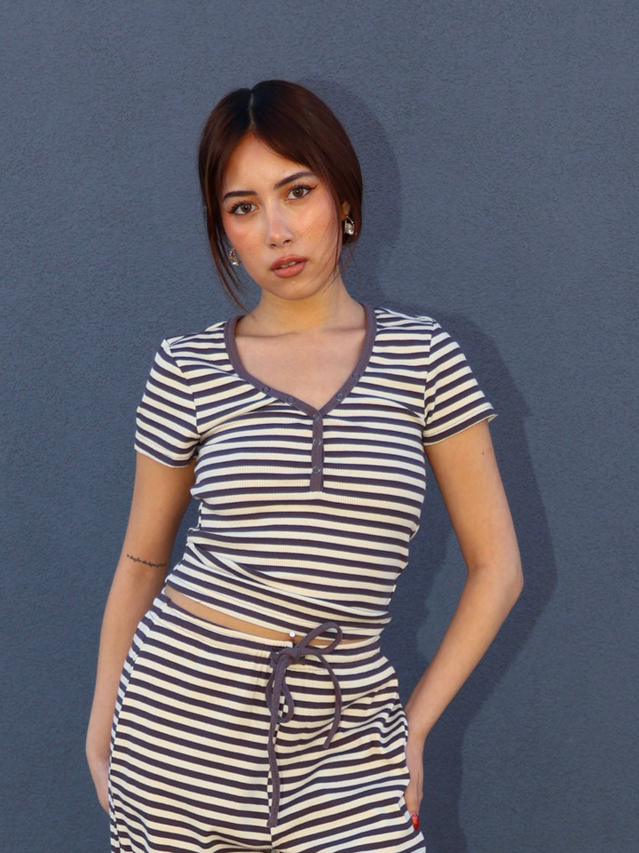 Woman wearing a striped dress against a blue background