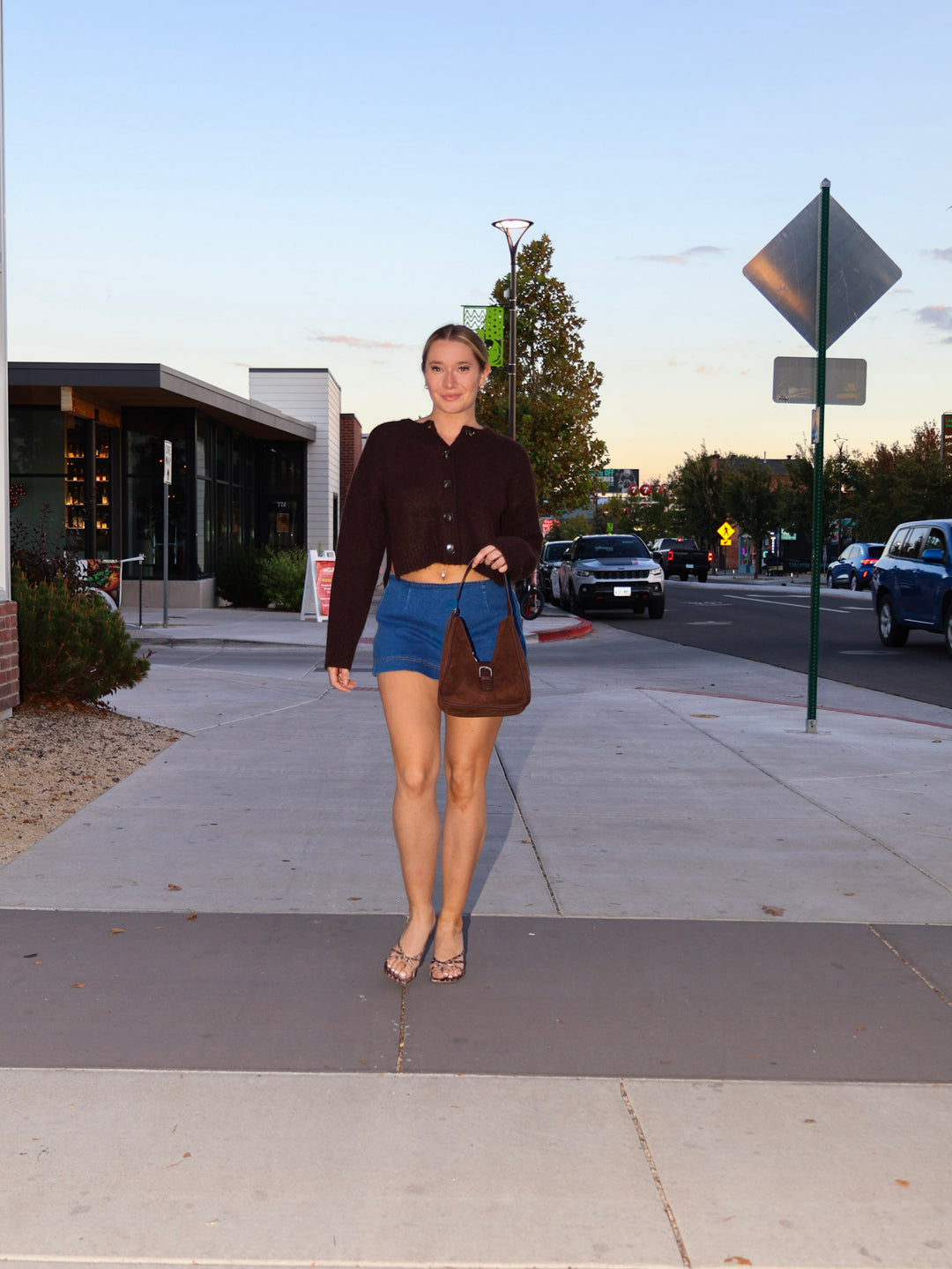 Woman walking on a sidewalk with a street and cars in the background