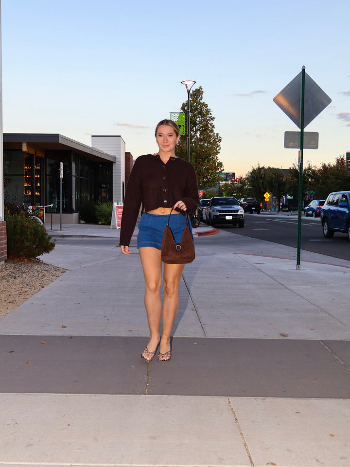 Woman walking on a sidewalk with a street and cars in the background