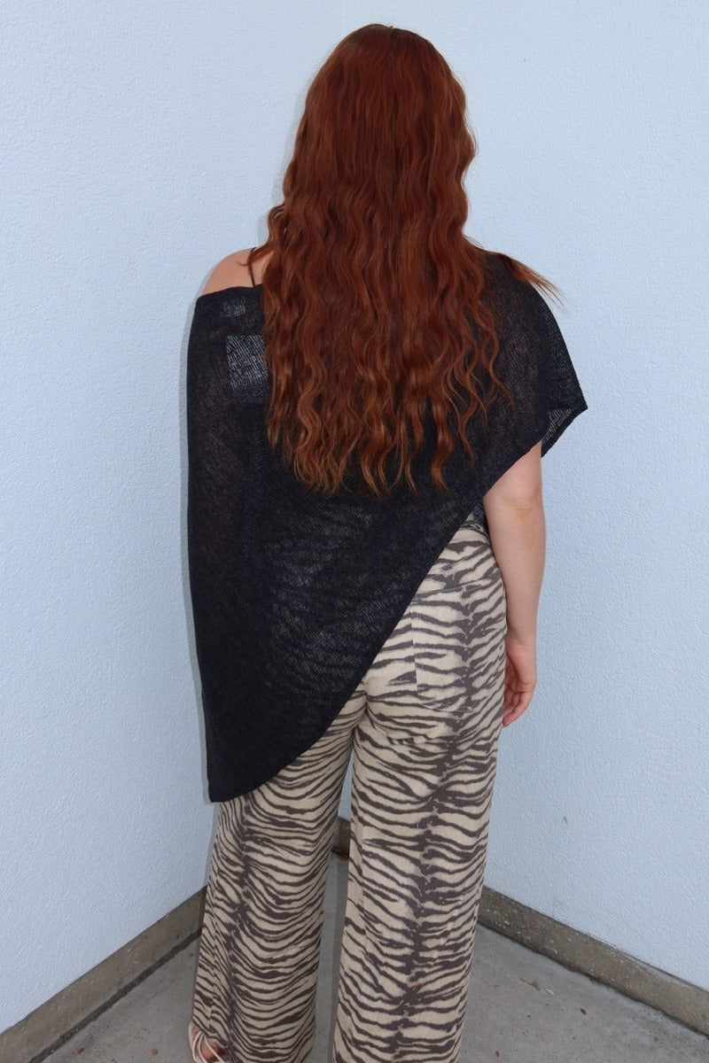 Angled back view of the black Portofino sheer knit poncho top, showing the draped asymmetric shape