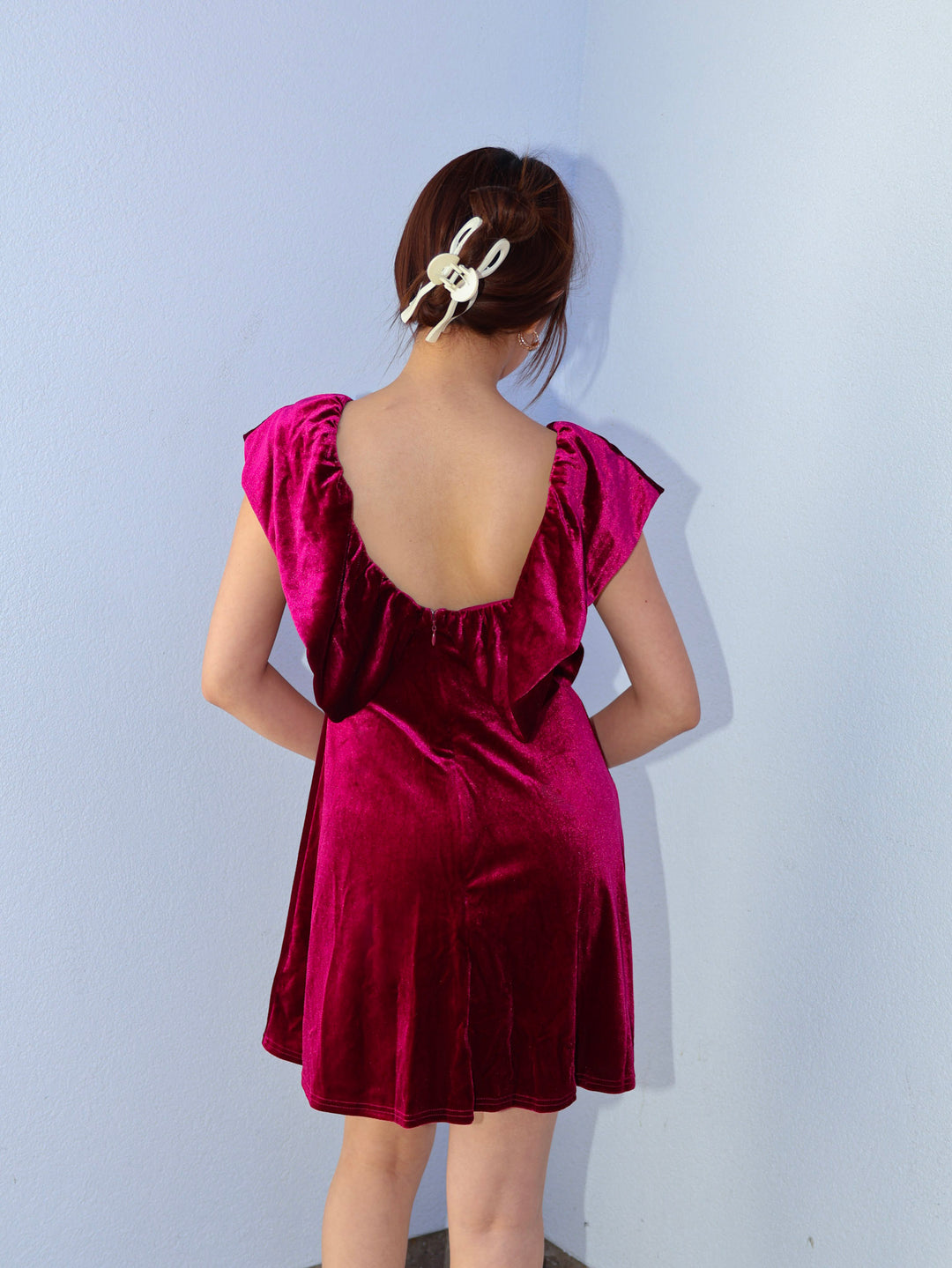 Woman wearing a burgundy dress with a plain background