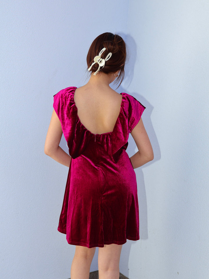 Woman wearing a burgundy dress with a plain background