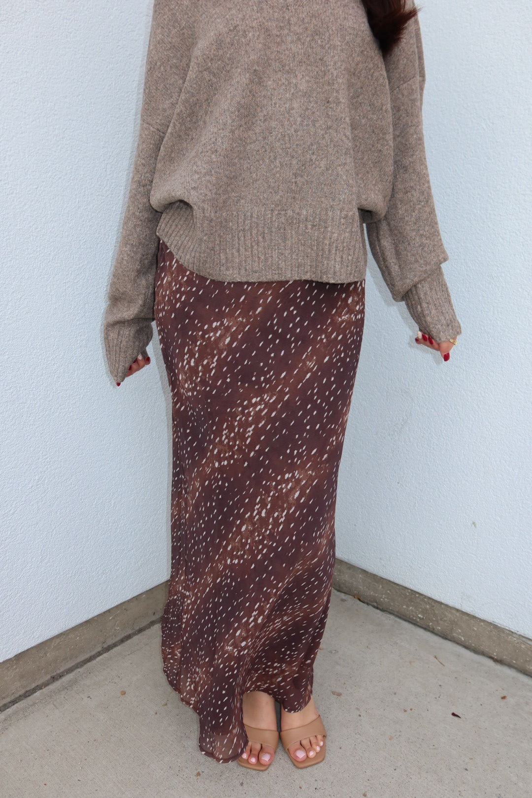 Close view of the burgundy print Bambi fluid maxi slip skirt, showing the ankle length drape with tan heeled sandals