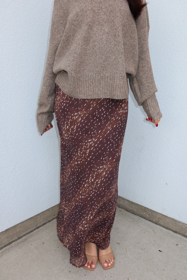 Close view of the burgundy print Bambi fluid maxi slip skirt, showing the ankle length drape with tan heeled sandals