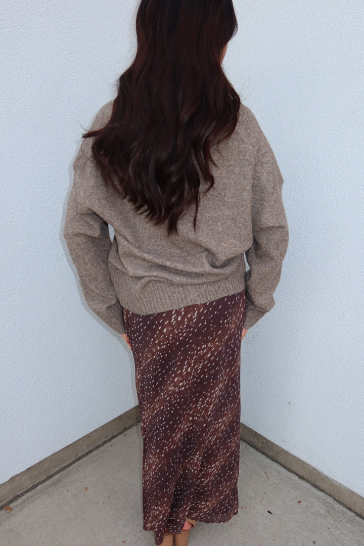 Back view of the burgundy print Bambi fluid maxi slip skirt with an oversized taupe sweater