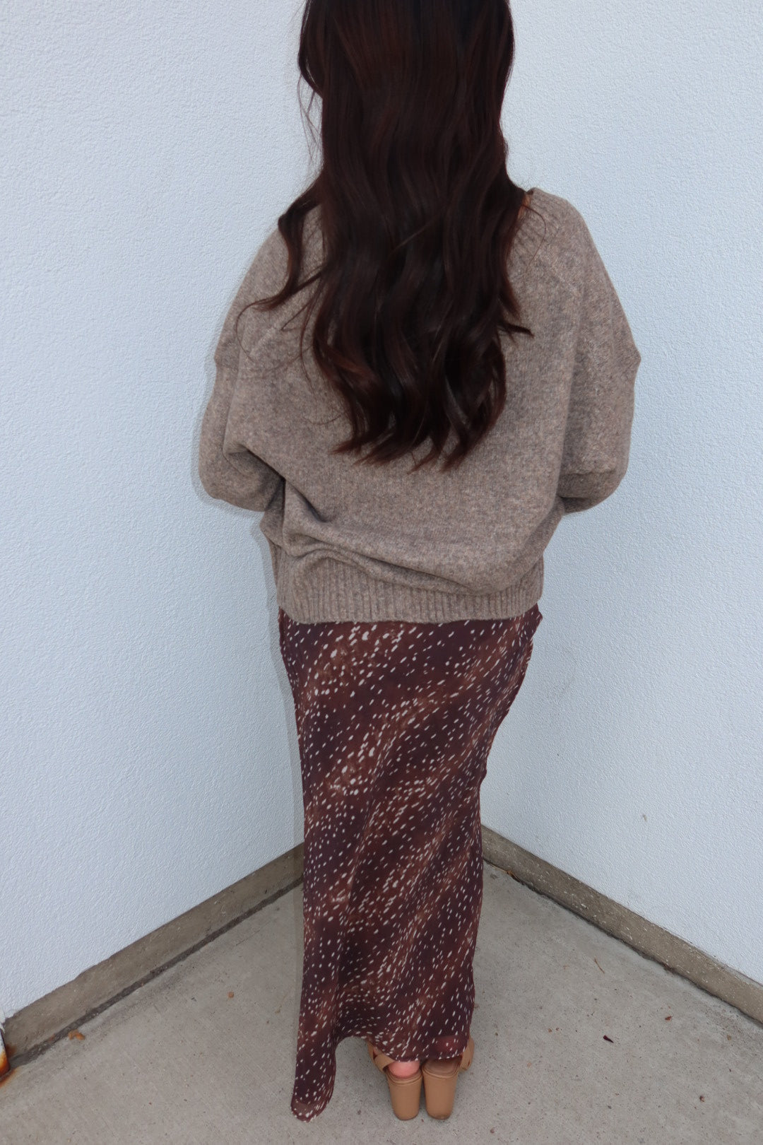 Back view of the taupe Viloria V-neck oversized sweater and burgundy print Bambi fluid maxi slip skirt