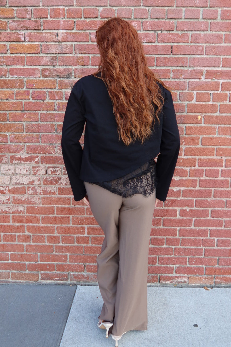 Back view of the black Charlie asymmetric lace trim top with the taupe Billie tailored wide leg trousers, full length