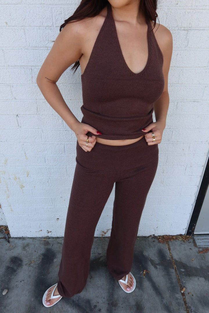 Close view of the brown Kelsey knit halter top with matching trouser, hands on hips showing the cropped hem