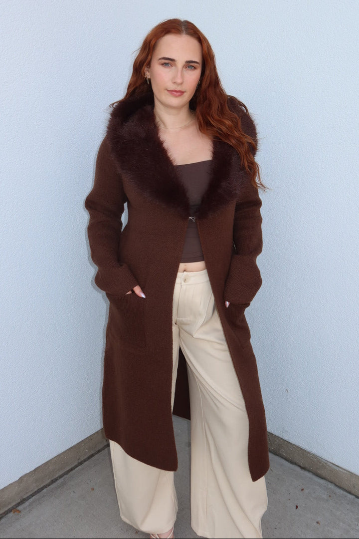 Front view of the brown Felicity faux fur collar cardigan, buttoned at the collar and worn with cream wide leg pants
