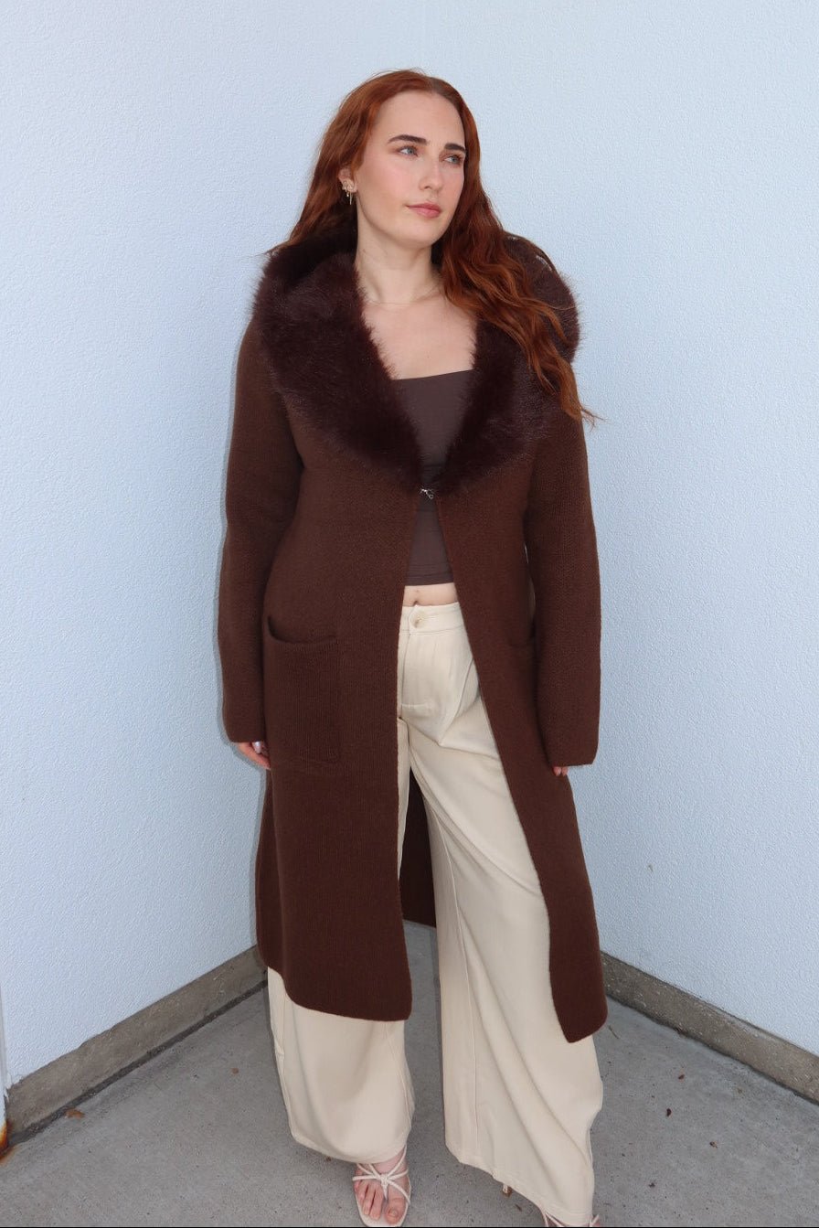 Model in the brown Felicity faux fur collar cardigan, open over cream wide leg pants, full length front view