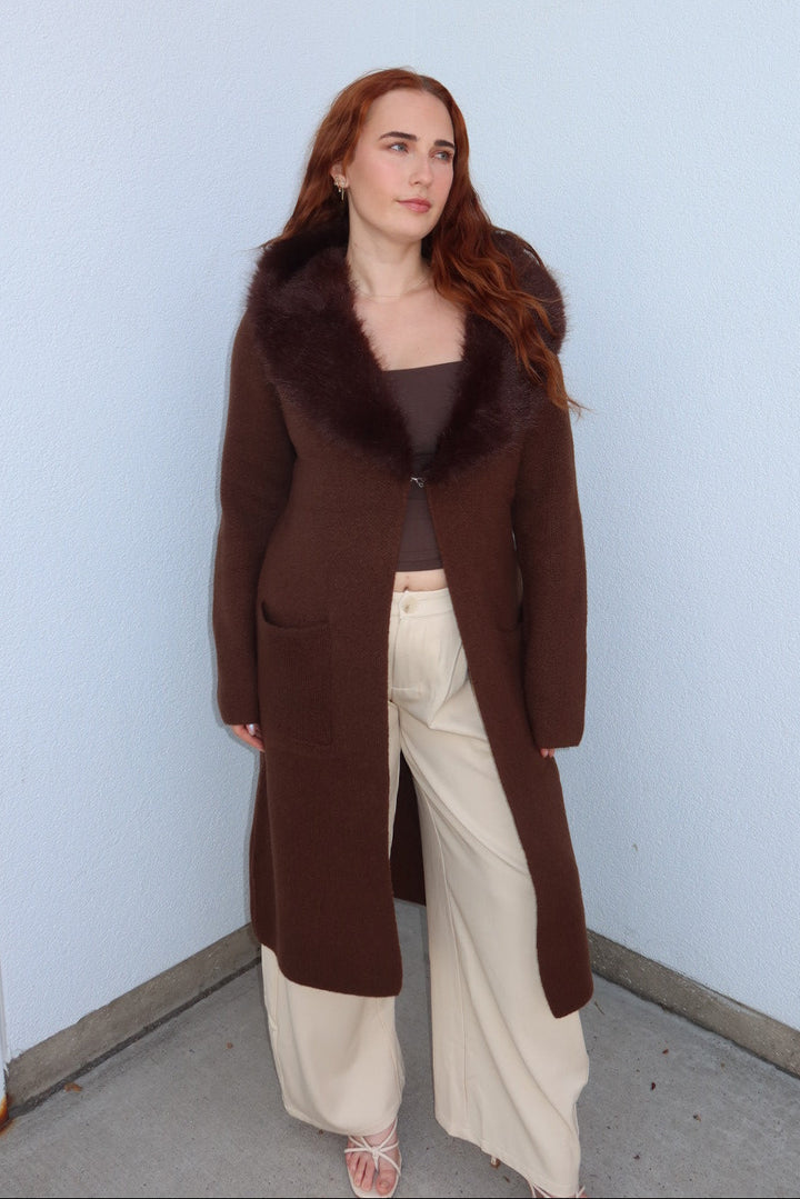 Model in the brown Felicity faux fur collar cardigan, open over cream wide leg pants, full length front view