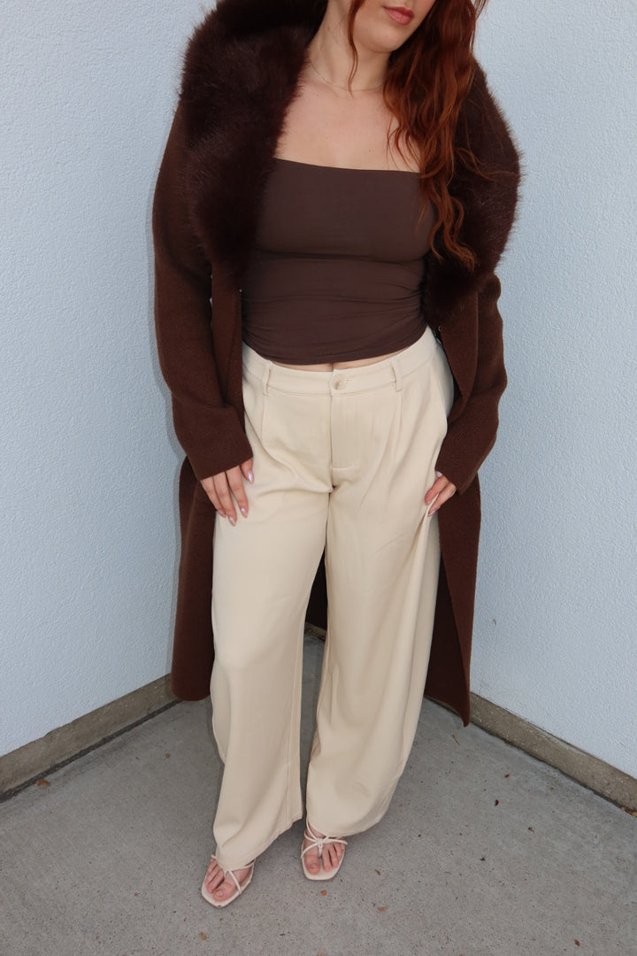 Front view of the cream Louis low waist pleated barrel wide leg pants with a brown top and strappy sandals