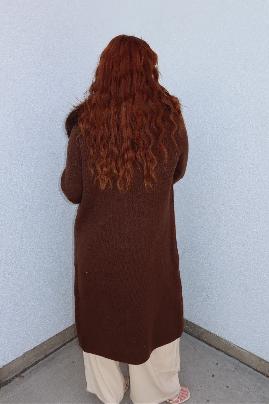 Back view of the brown Felicity faux fur collar cardigan, showing the long knee length body